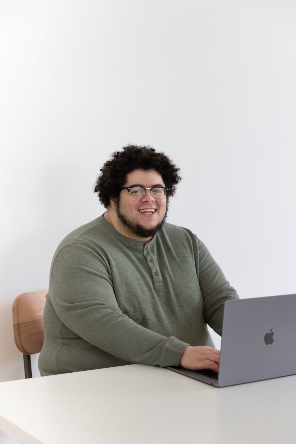 Alex Storey smiling at his laptop